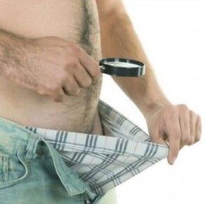 a man looks at his pants and wants to enlarge his penis with gel